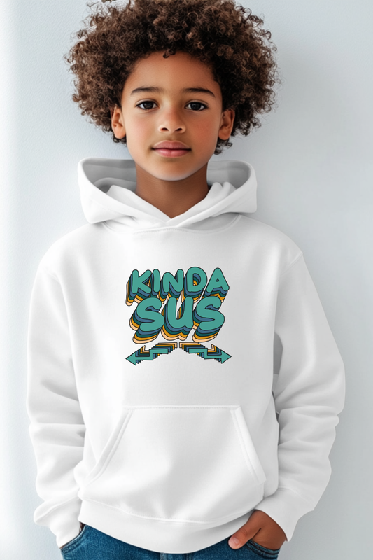 A young boy stands against a plain background wearing a white hoodie with a vibrant “KINDA SUS” graphic, showcasing a playful, trendy style.