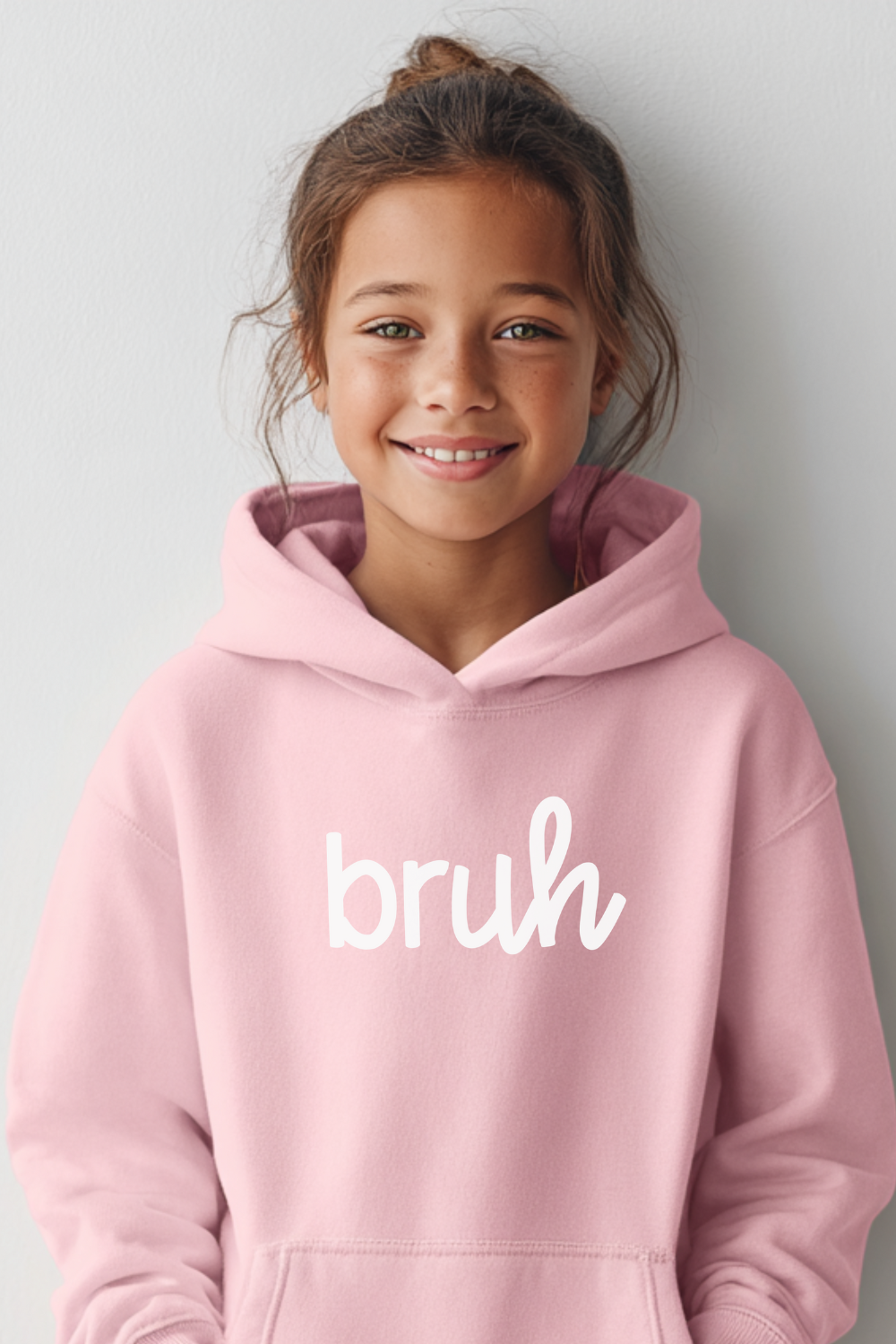 Say it with style: BRUH. This cozy light pink hoodie is a funny graphic sweatshirt made for kids, teens & adults. Available in youth & adult sizes up to 5XL — perfect for family matching outfits, birthday gifts, or everyday streetwear style.