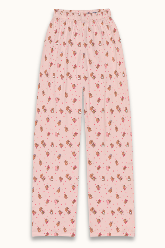 Adorable capybara print lounge pants in soft Shell Pink, featuring playful capybaras and tiny plushie icons scattered across cozy brushed polyester fabric. A cute, unisex pajama bottom perfect for kids, tweens, and teens who love fun, pastel sleepwear. Ideal for gifting, sleepovers, and cozy nights in.