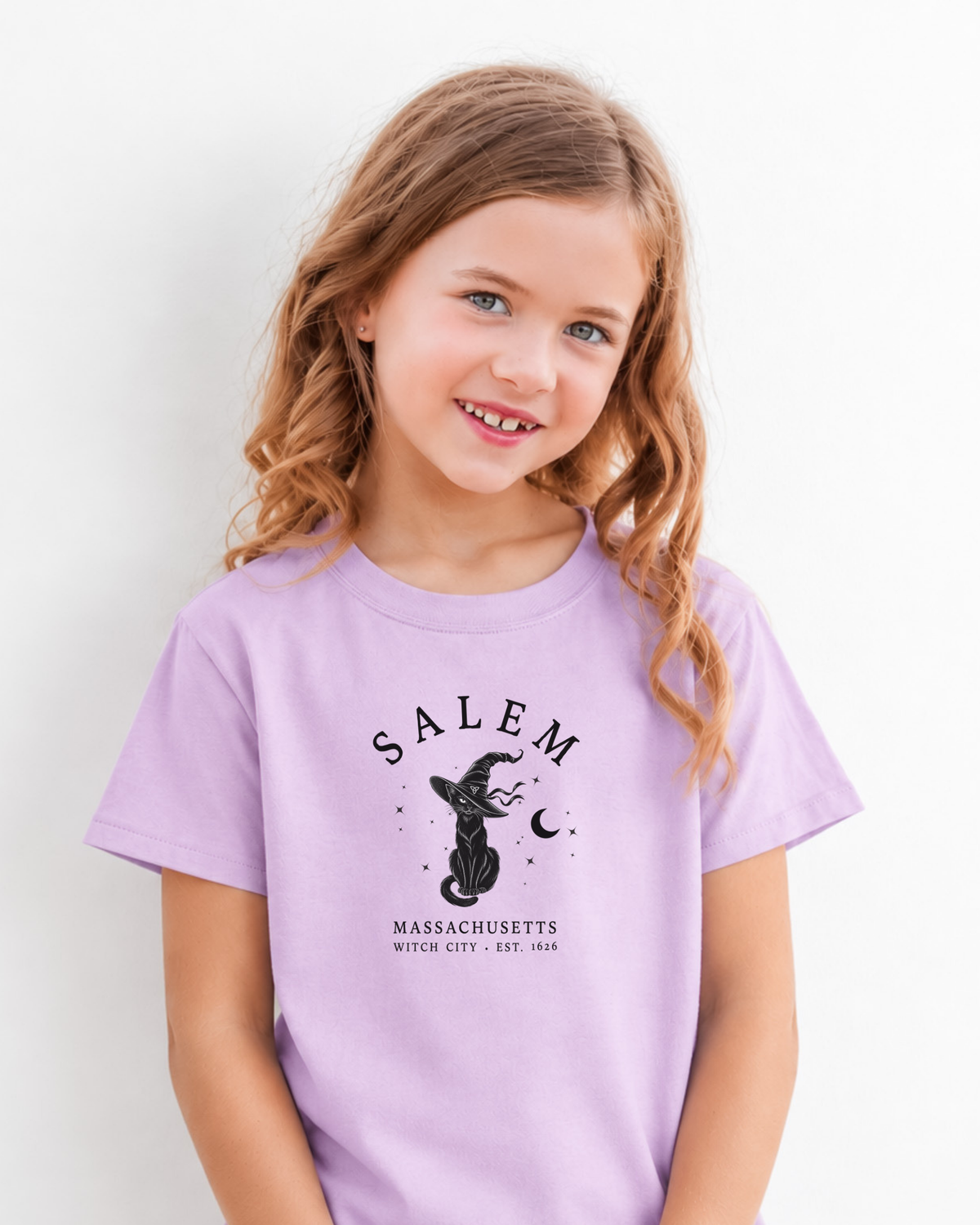 Girl wearing a lavender youth T-shirt with black Salem Massachusetts Witch City graphic featuring a cat in a witch hat and crescent moon.